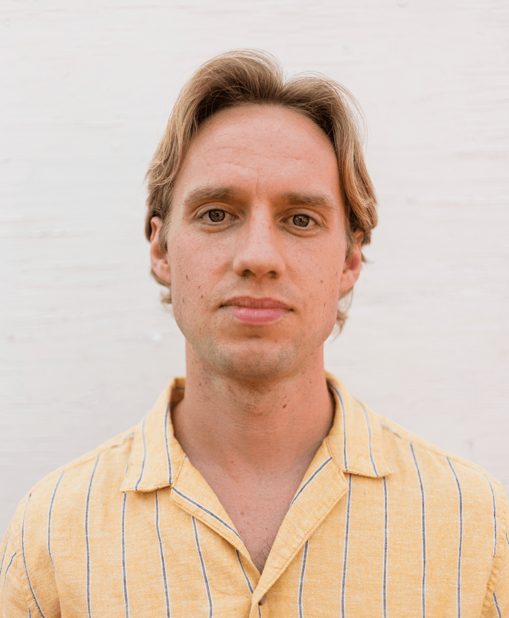 A headshot of Cameron in a yellow shirt