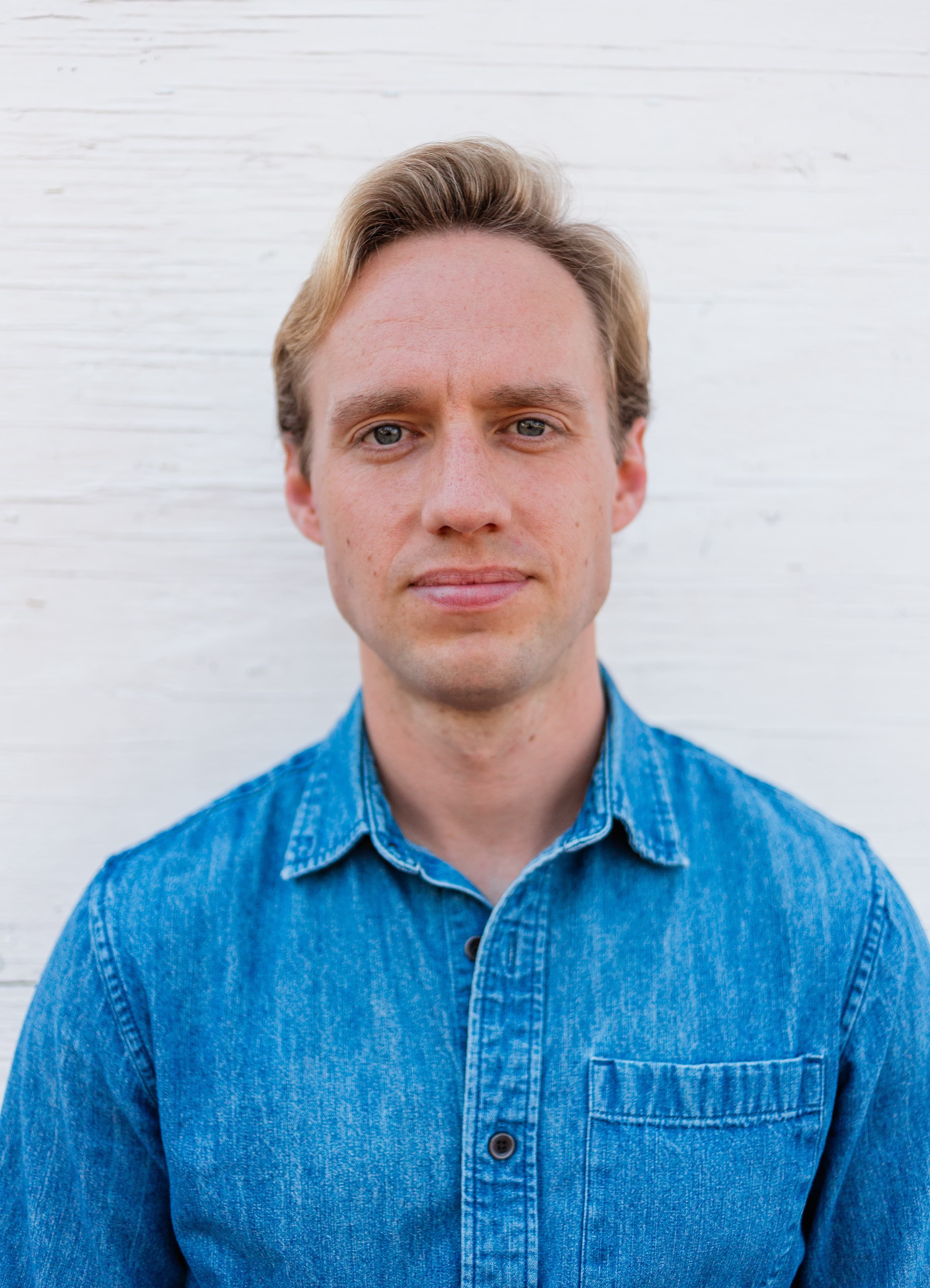 A headshot of Cameron in a yellow shirt