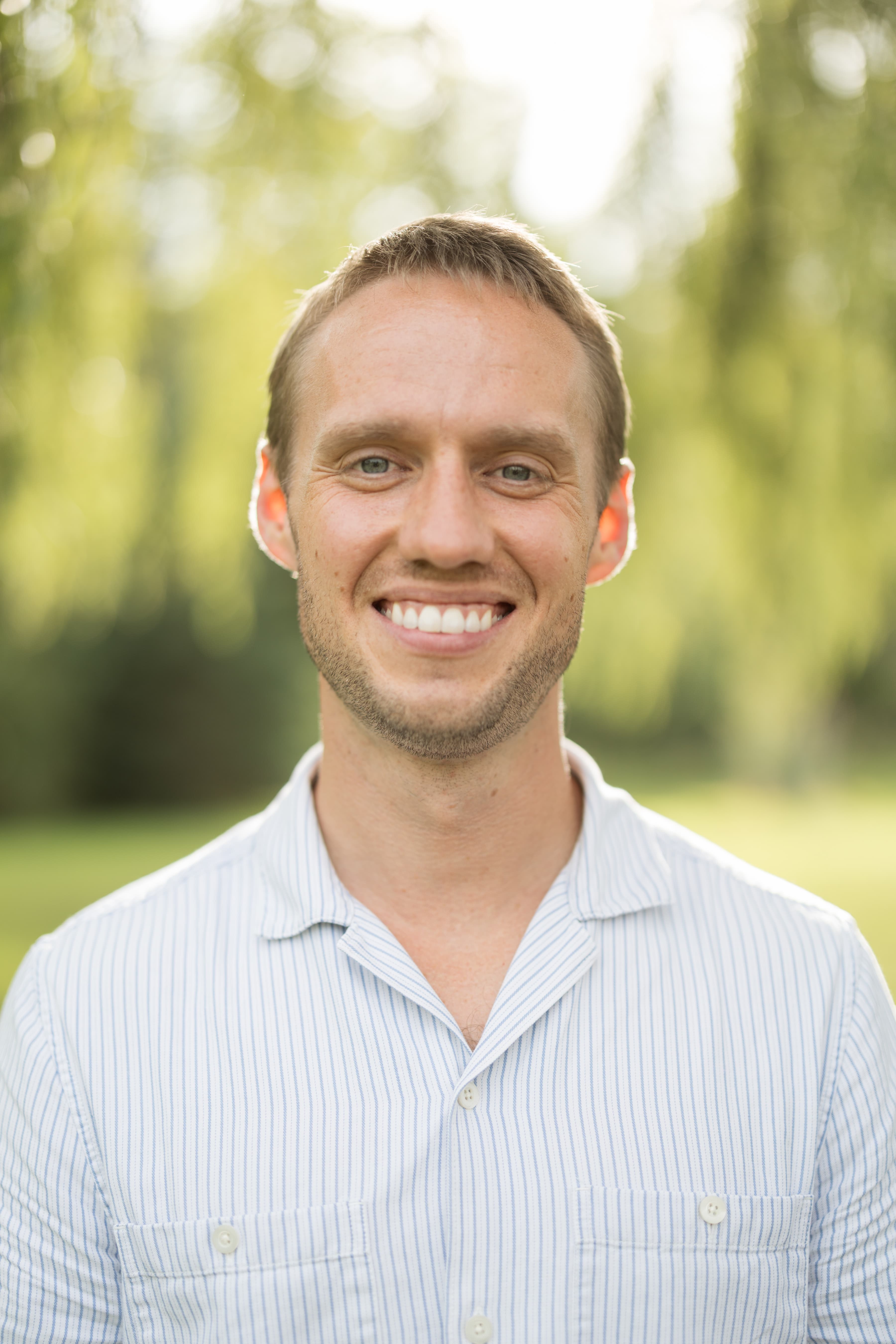 A headshot of Cameron in a yellow shirt